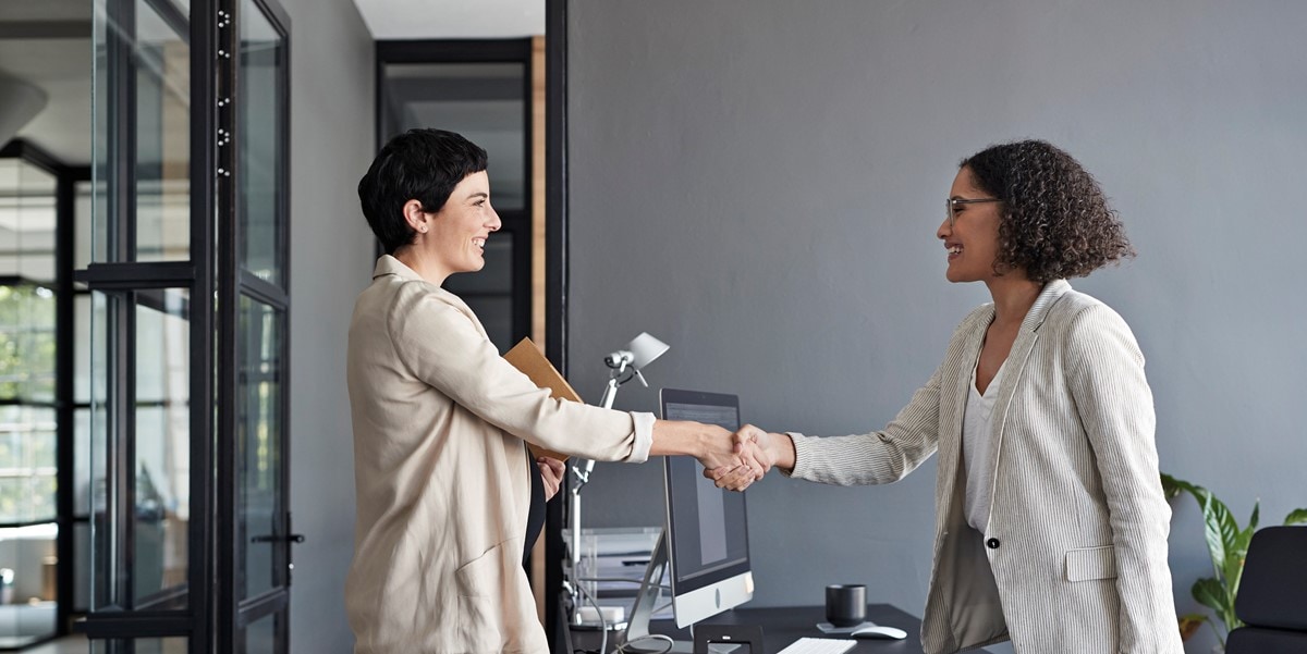 two women shaking hands in the office